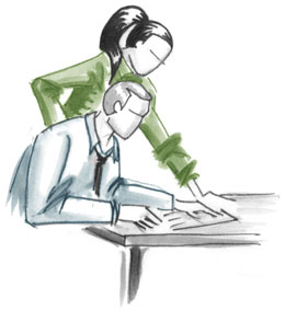 Two people work together at a desk.